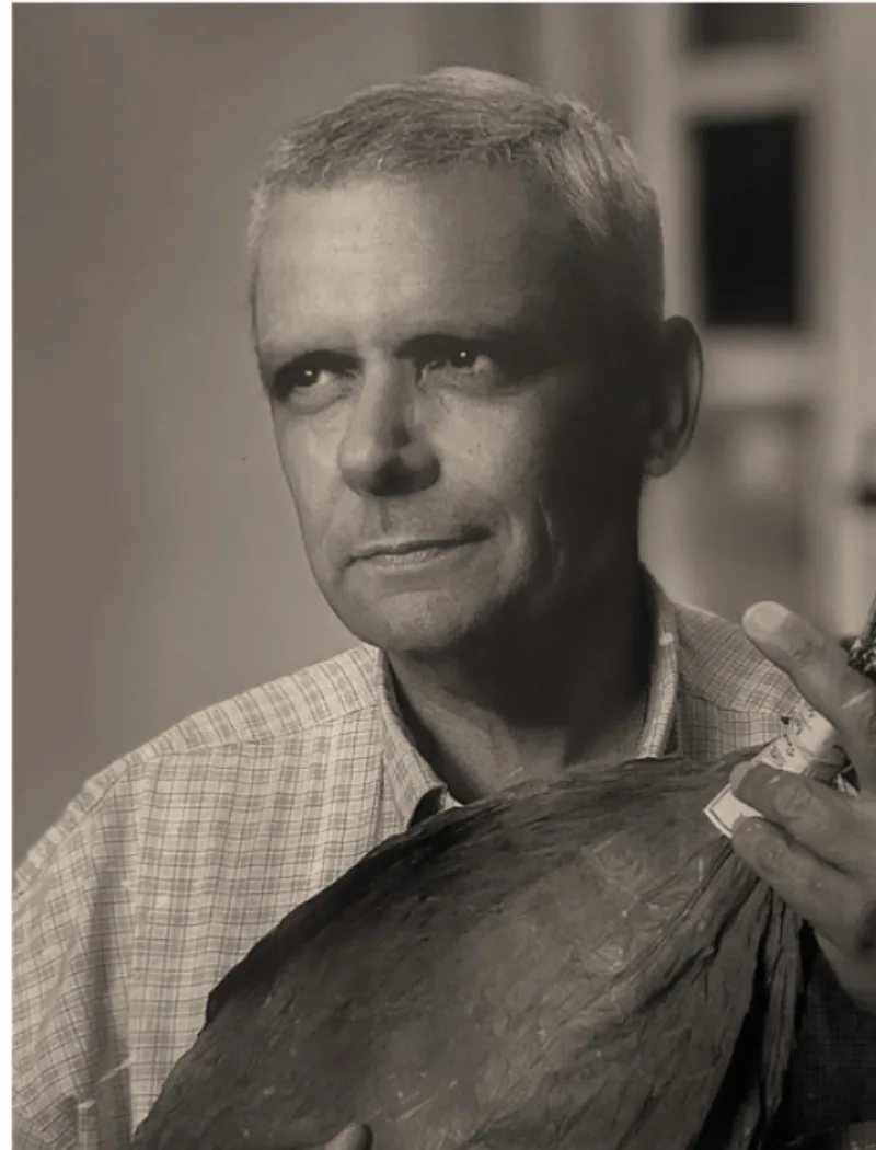 Néstor Plasencia holding a tobacco leaf